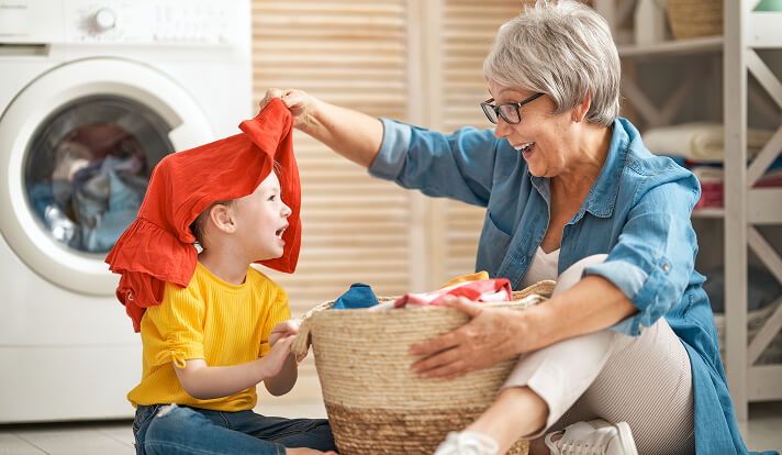 child with grandmother doing laundry