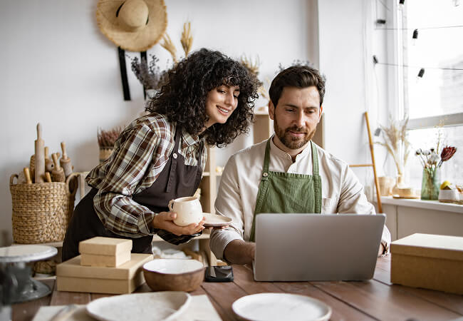 a couple at home viewing a laptop screen